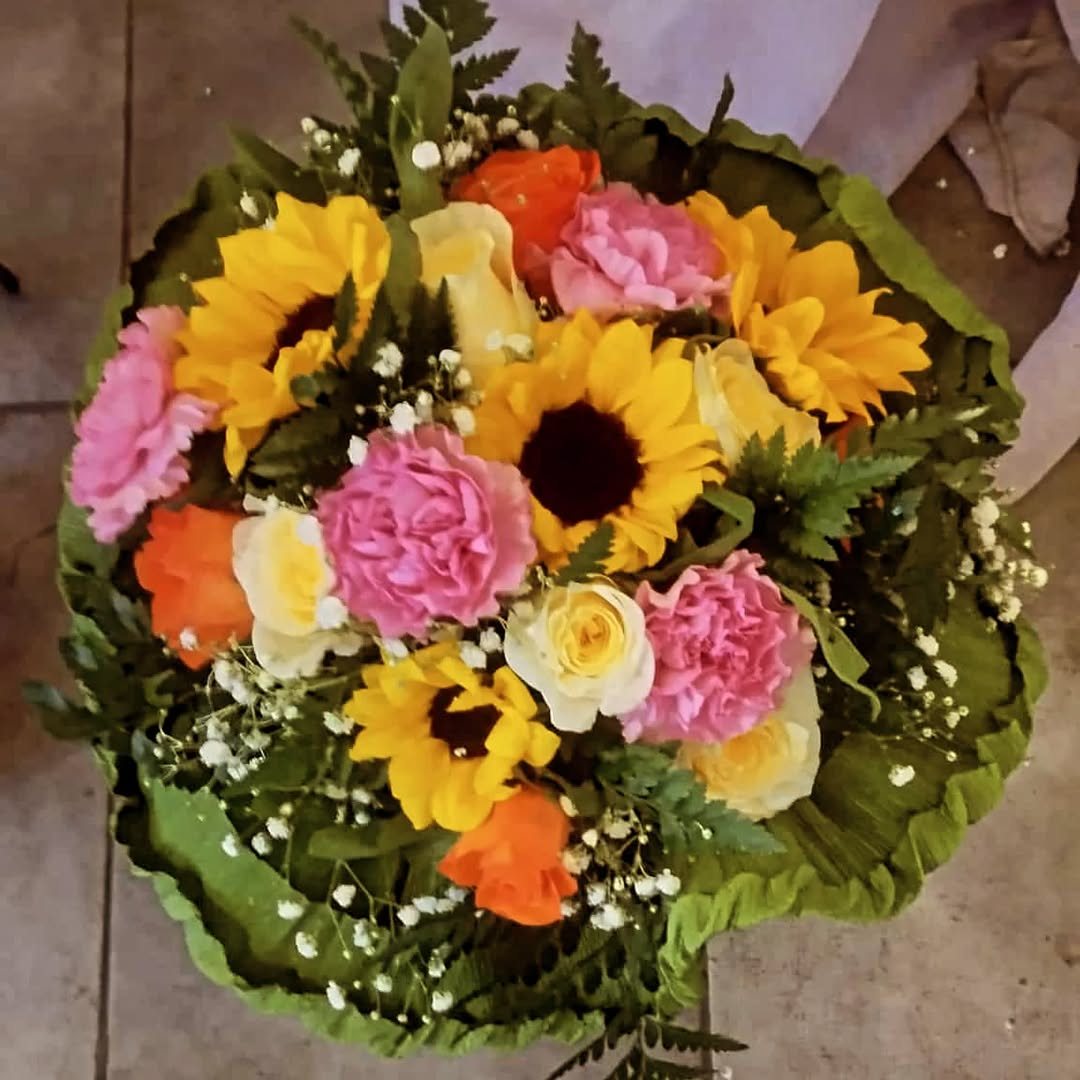 Bouquet con girasoli, garofani rosa, rose gialle e arancioni