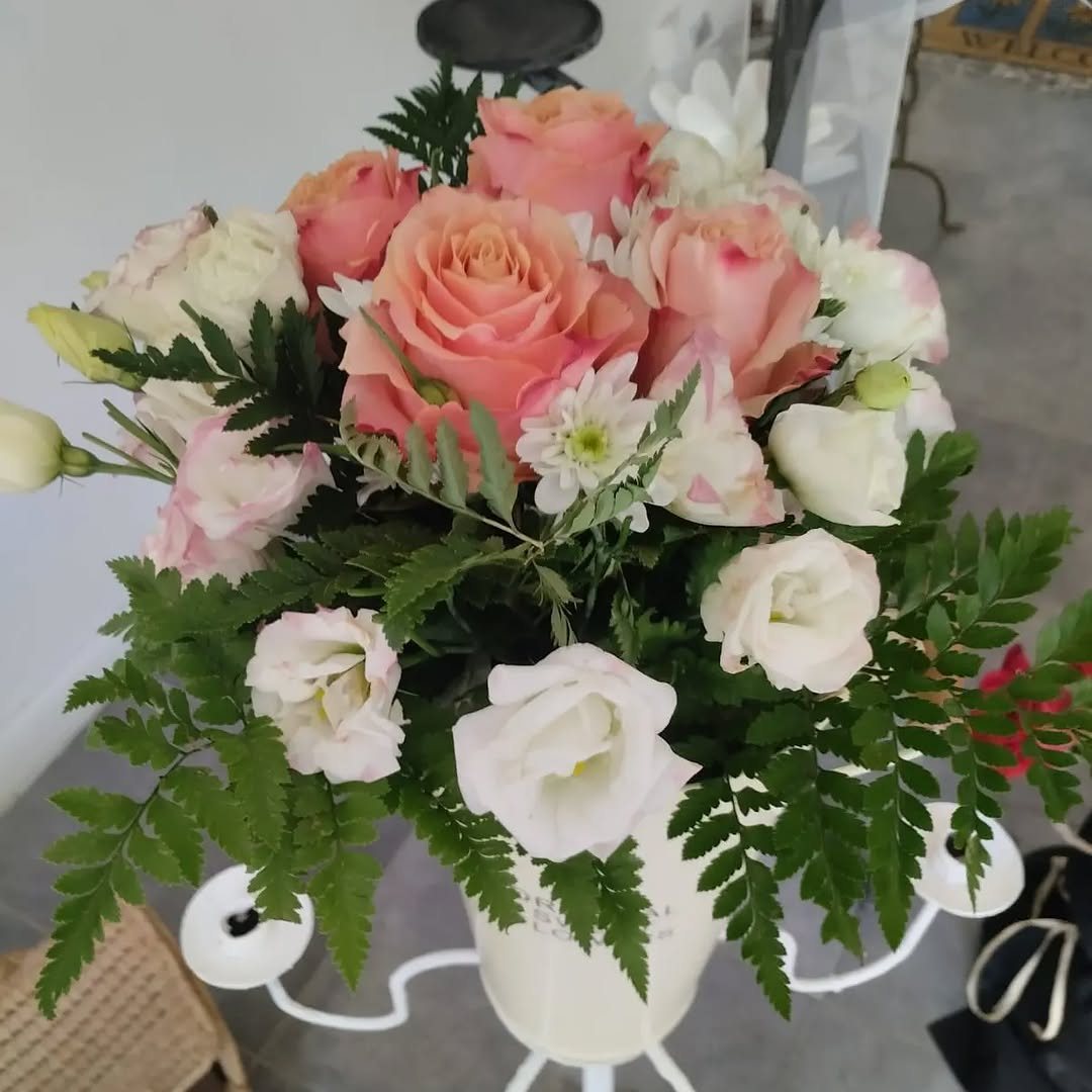 Candelabro fiorito con rose pesca, lisianthus bianchi e margheritine
